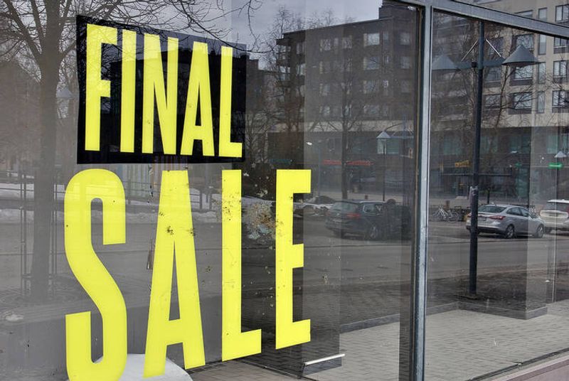 Näyteikkuna, jossa teksti ”FINAL SALE”. Ikkunasta heijastuu katu, autoja ja kerrostaloja. 