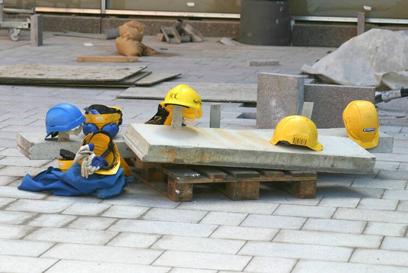 Rakennustyöntekijöiden keltaisia kypäriä rakennustyömaalla