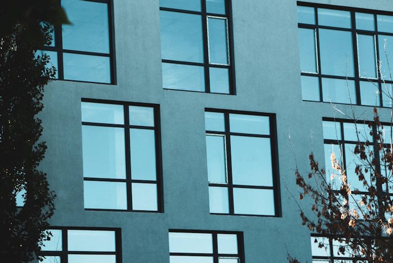 Valokuvassa modernin kerrostalon ikkunoita.