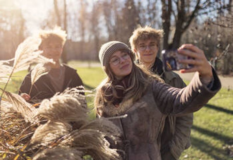 Nuoria kuvaamassa kännykällä.