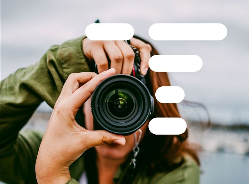 Nainen pitää kädessään kameraa.